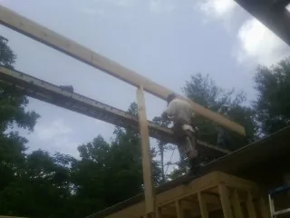 Carpenter setting a ridge beam over a new addition frame — Ice Dam Removal by Roofing Brothers in Sylvia