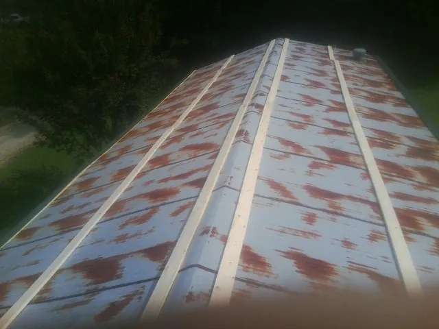 Rusted metal roof panels with new wood purlins before replacement — Storm Damage Roof Repair in Sylvia by Roofing Brothers
