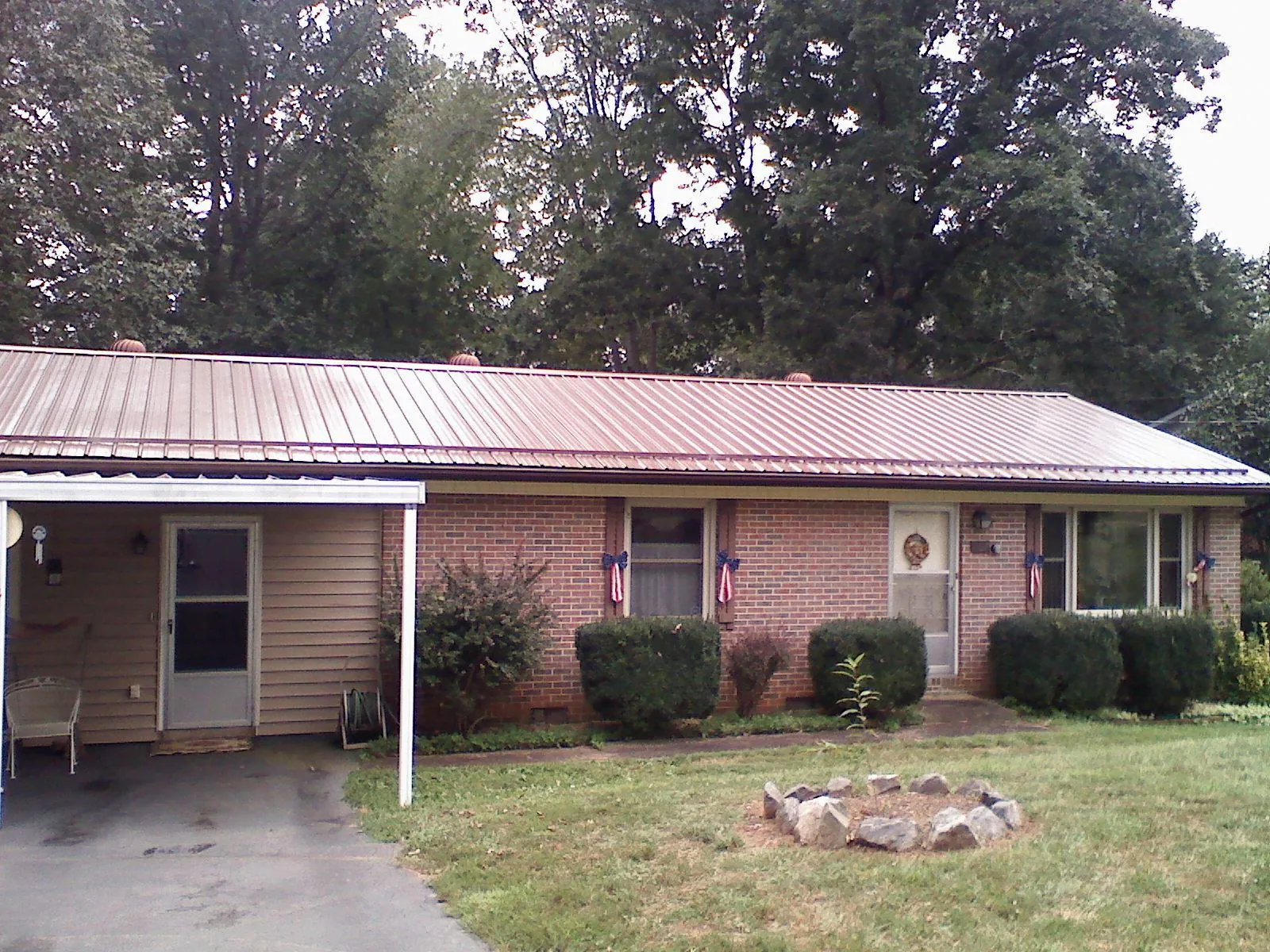 Bronze metal roof and carport on a brick ranch home — Roof Repair work by our crew in Sylvia