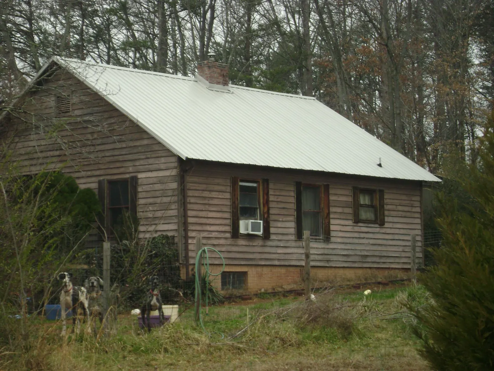 White metal roof on an old wood sided farmhouse, from a Metal Roof Installation job in Sylvia